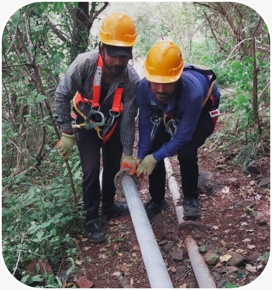 Pipeskool team installing pipeline through forested terrain, Palitana